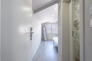a white room with a bed and a hallway at Rua Grande Hotel in Viana do Castelo +162 photos