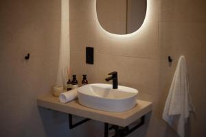 a white sink in a bathroom with a mirror at Öreg-kő 1478 in Bajót +8 photos