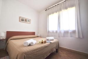 a bedroom with two beds with towels and a window at Le Dimore di Nettuno in Olbia