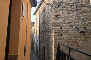 an alley with a brick wall and a building at Torre del Borgo - Centro Storico di Accettura in Accettura