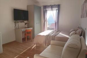 a bedroom with a bed and a couch and a window at Torre del Borgo - Centro Storico di Accettura in Accettura