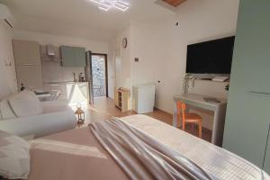 a living room with a bed and a table and a kitchen at Torre del Borgo - Centro Storico di Accettura in Accettura