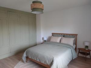 a bedroom with a large bed with a wooden headboard at Logement cosy proche Cluny in Buffières