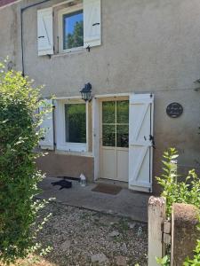 a door of a house with a dog standing outside at Logement cosy proche Cluny in Buffières