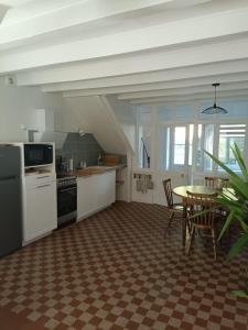 a kitchen with a table and a table and chairs at Logement cosy proche Cluny in Buffières