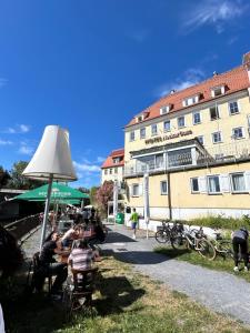 a group of people sitting at a table in front of a building at Hotel NeckarOase in Lauffen am Neckar