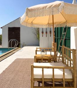 two chairs and an umbrella next to a pool at Vistâme in Almoster
