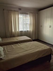 ein Schlafzimmer mit zwei Betten und einem Fenster in der Unterkunft Safespace in Cravenby