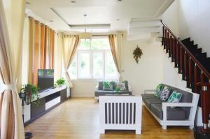 a living room with a couch and a tv at Vila Mũi Né-Phan Thiết in Ấp Ngọc Hải