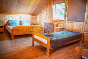 a bedroom with two beds in a wooden room at Chata Ujo in Hranice