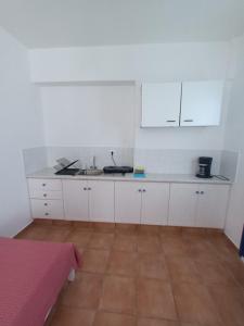 a kitchen with white cabinets and a sink at Evdokia3 in Koufonisia