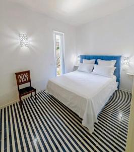 a bedroom with a large white bed and a chair at Minnelea Blue Retreat in Acciaroli