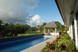 a swimming pool with a gazebo next to a house at Sikeci Villa in Pacific Harbour
