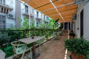 an outdoor patio with tables and chairs and plants at Porto Sol Hotel Bodrum in Bodrum City