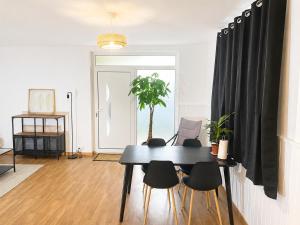 a dining room with a black table and chairs at Independent 2-room apartment in Senhora da Hora