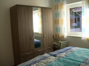 ein Schlafzimmer mit einem großen Holzschrank und einem Bett in der Unterkunft Ferienhaus Am Barenberg in Thülsfeld
