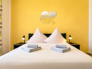 a bedroom with a white bed with hearts on the wall at Neptun in Kołobrzeg