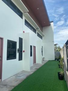 a white house with a green lawn at ZK Loft Staycation Gensan in General Santos