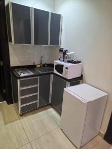 a small kitchen with a microwave and a sink at Art Suite in Riyadh