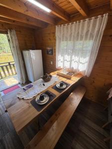 a room with a wooden table in a cabin at Cabanas em Canela - Leão da Tribo de Judá- Refúgio com Piscina in Canela