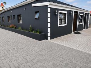 a blue building with a brick driveway at Springforth Guesthouse in De Grendel