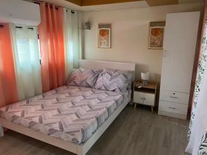 a bedroom with a bed with an orange curtain at ZK Loft Staycation Gensan in General Santos