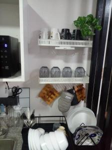 a kitchen with a cupboard with dishes and utensils at Unit 207C Amani Grand Resort & Residences in Pusok
