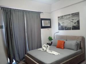 a bedroom with a couch with a white animal on it at Unit 207C Amani Grand Resort & Residences in Pusok
