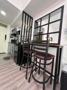 a kitchen with two chairs and a bar with a counter at Unit 207C Amani Grand Resort & Residences in Pusok