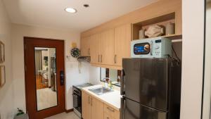 a kitchen with a black refrigerator and a microwave at The Mosaic Tower Luxury Boutique Studio,Pool and Gym Fast Wifi in Manila