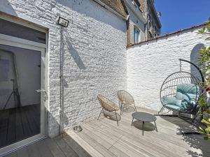 a patio with two chairs and a table next to a building at Charmante maison in Namur