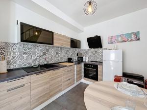 a kitchen with a white refrigerator and a table at Charmante maison in Namur +5 photos