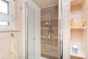 a shower in a bathroom with wooden walls at Hausboot Sophie in Stralsund in Stralsund +8 photos