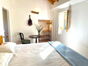 a bedroom with a bed and a table and a window at Bombom Comporta in Melides