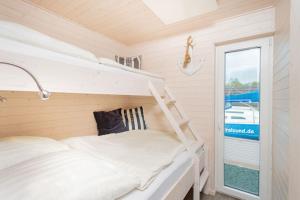 a bunk bed in a tiny house with a window at Hausboot Sophie in Stralsund in Stralsund
