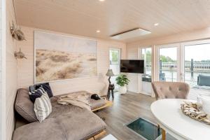 a living room with a couch and a table at Hausboot Sophie in Stralsund in Stralsund