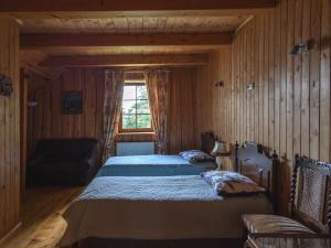 a bedroom with two beds and a couch and a window at Kaimo sodyba Senas rublis in Pesčiai