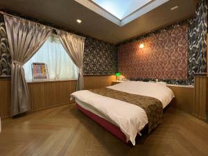 a bedroom with a large bed and a window at ホテルレイクイン in Ono