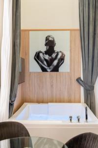 a bath tub with a picture of a man at Kore Luxury Suite e Spa in Naples