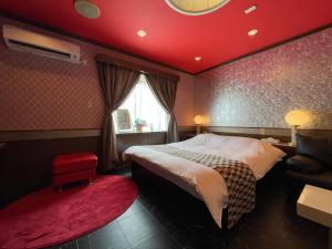 a bedroom with a bed and a red ceiling at ホテルレイクイン in Ono