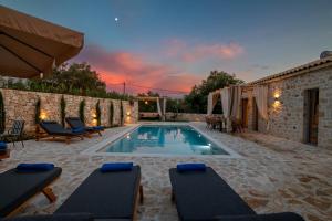 a swimming pool with chairs and a villa at TS Luxury villa in Velianitátika