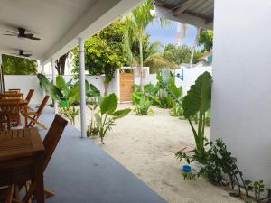a patio with a table and chairs and plants at Salt Serenity in Thoddoo