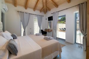 a bedroom with a large bed and a balcony at TS Luxury villa in Velianitátika
