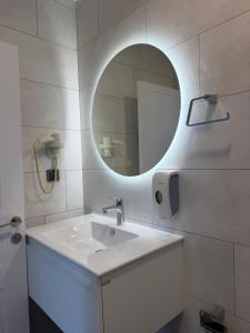 a bathroom with a white sink and a mirror at Armeda Restoran ve Pansiyon in Datca
