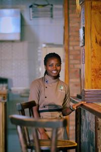a woman sitting in a chair next to a table at Akagera Transit Lodge in Akagera