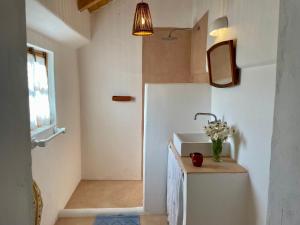 a bathroom with a sink and a vase of flowers at Bombom Comporta in Melides
