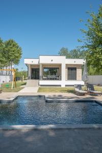a house with a swimming pool in front of a house at Drina Lux in Loznica