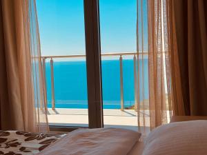 a bedroom with a window with a view of the ocean at Tophill Altezza 9 Breathtaking Views and Terrace in Budva