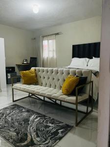 a living room with a couch and a bed at Rest Easy Guest House Pty Ltd Unit 5 in Boksburg