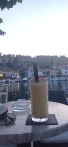 a drink on a table with a view of the water at Apartman Vida in Zaton